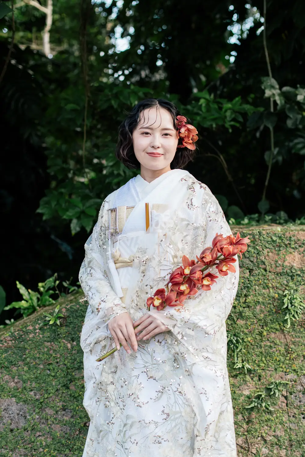 白無垢を着て、赤い花を手にした女性